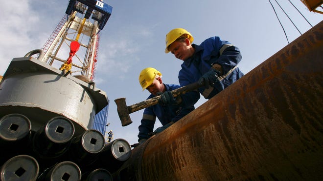 Oil Workers Look Into Gas Field