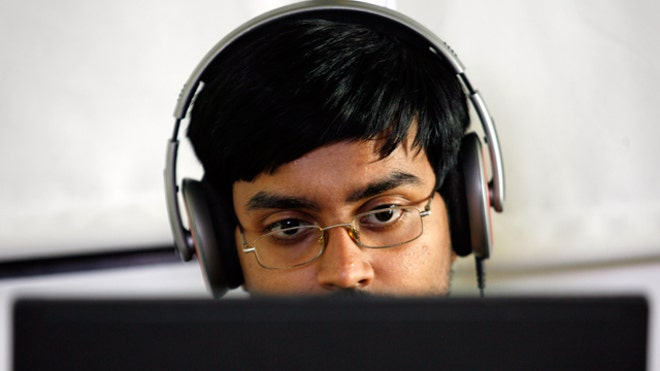 Headphones Guy Works on Laptop Reuters