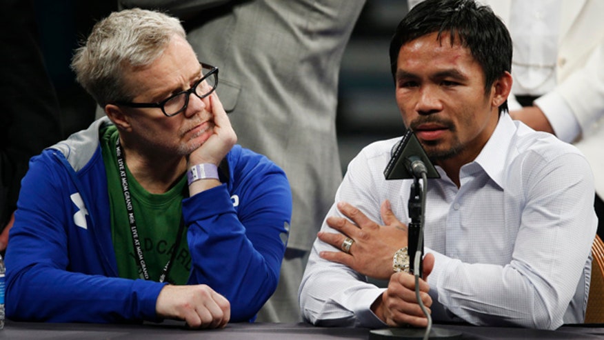 FILE - In this May 2, 2015 photo, trainer Freddie Roach, left, listens as Manny Pacquiao answers questions during a press conference following his welterweight title fight against Floyd Mayweather Jr. in Las Vegas. (AP Photo/John Locher)