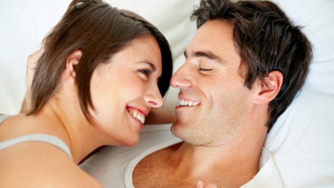 smiling couple in bed
