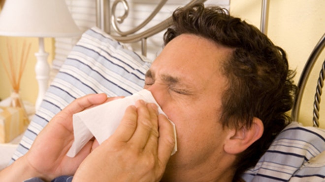Man sick in bed with flu iStock