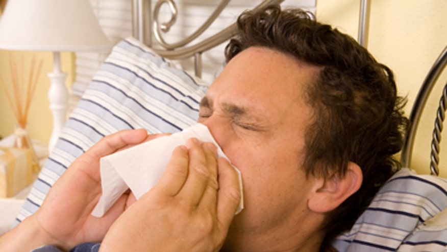 Man sick in bed with flu iStock