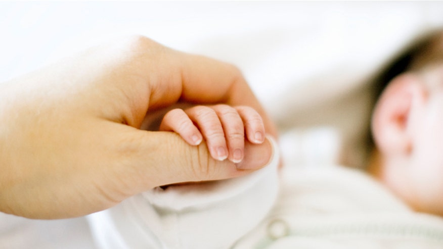 Mom holding baby hand istock.jpg