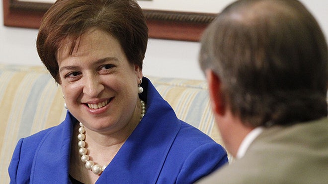 Elena Kagan in blue coat on couch