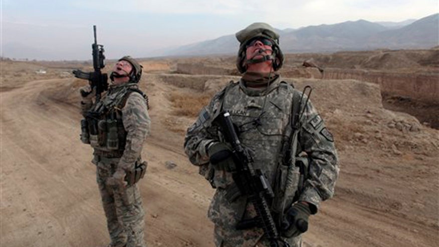 Two U.S. troops look at the Afghan skyline