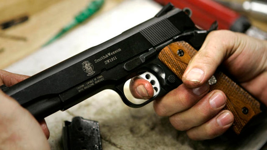 FILE: Undated: A model 1911 pistol is held in the hands of an assembler at the Smith & Wesson factory in Springfield, Mass.