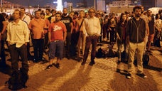 Turkey's deputy prime minister gave a nod of approval to a new form of peaceful resistance that is spreading through Turkey on Wednesday as police were questioning dozens of people rounded up in police raids.