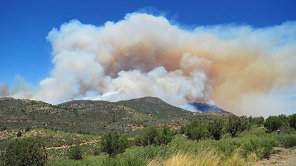 A new wildfire in the foothills southwest of Denver forced the evacuation of dozens of homes Wednesday as hot and windy conditions in much of Colorado and elsewhere in the West made it easy for fires to start and spread.