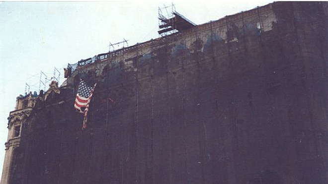 Tattered flag wide on building