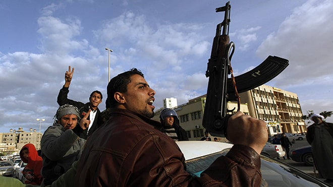 Libyan protester w gun screams against Qaddafi