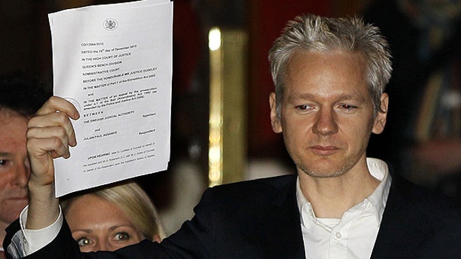 Assange, freed, holds up paper in London