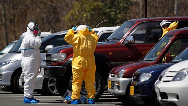 Japanese workers don protective suits