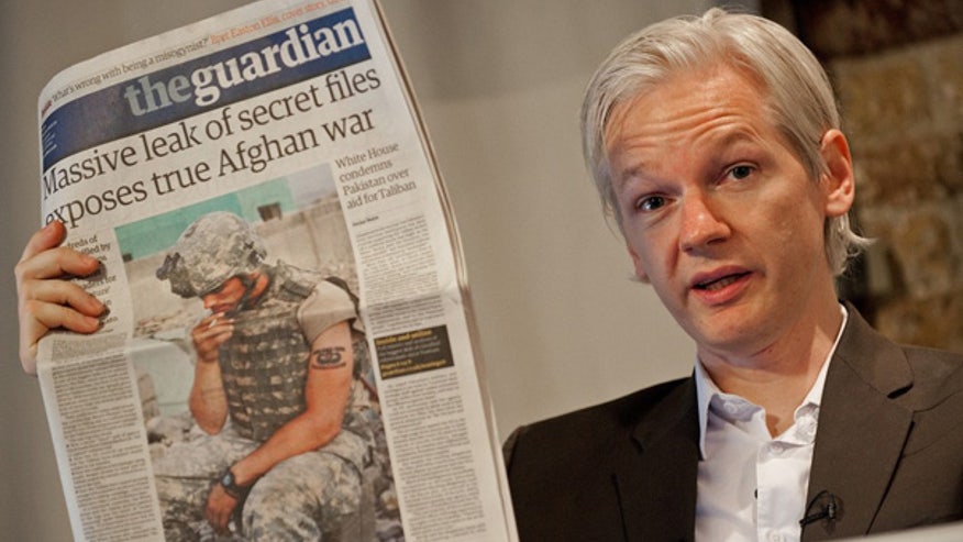 WikiLeaks founder Julian Assange holds up paper