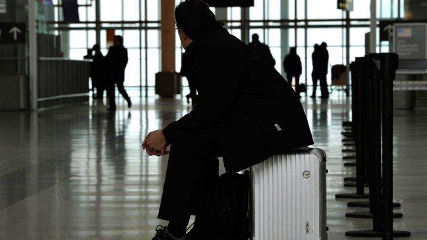 Traveler Sits on Suitcase