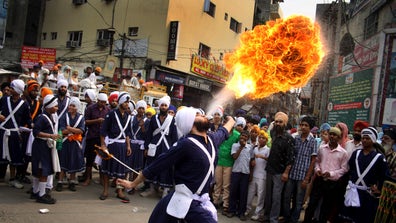 From a fire-breathing man in India to heart-breaking tornado scenes in the midwest, here are some of the most arresting images from the past week.