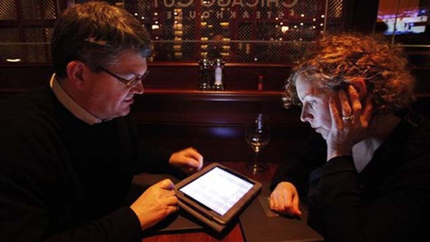 Couple hunched over ipad