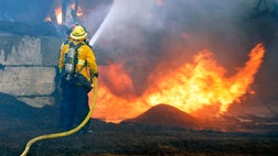  Firefighters gained ground on a wildfire that burned nearly  square miles of dry brush and forced people to evacuate part of Camp Pendleton, while a blaze generating heavy smoke drove some residents from homes in an Orange County canyon community.