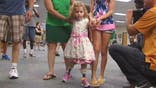 A toddler whose feet were amputated after her father accidentally backed over her with a riding lawnmower took her first steps on her new prosthetic test legs Monday.
