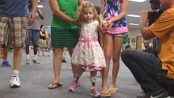 A toddler whose feet were amputated after her father accidentally backed over her with a riding lawnmower took her first steps on her new prosthetic test legs Monday.