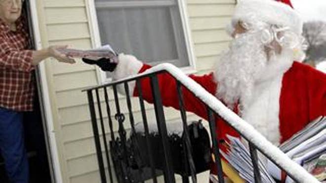A postal worker dressed as Santa Claus delivers the mail. Dec. 24, 2008