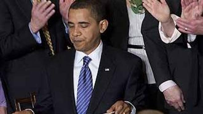 President Obama is applauded by members of Congress after signing an order on stem cells at the White House on March 9. (AP Photo)