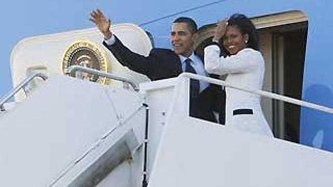 President Obama and first lady Michelle Obama wave before boarding Air Force One at Andrews Air Force Base in Maryland Tuesday. (AP Photo)