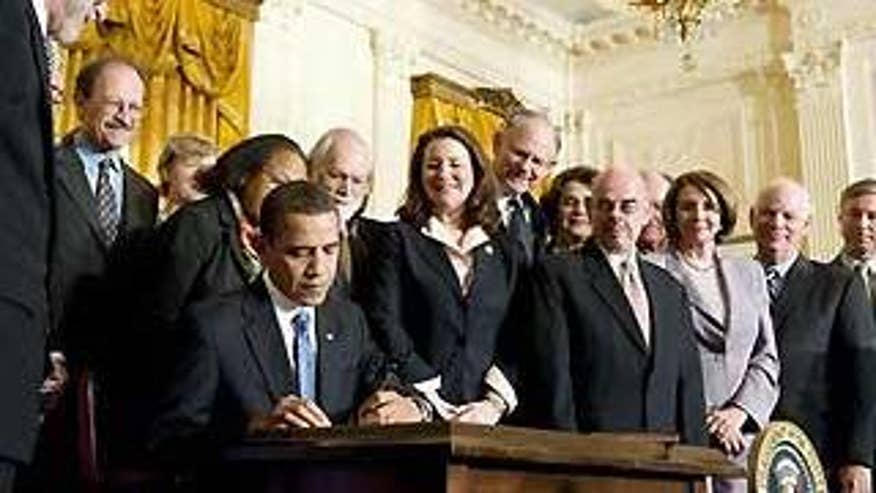 President Obama signs an order lifting restrictions on funding for stem cell research in Washington Monday. (Reuters Photo)