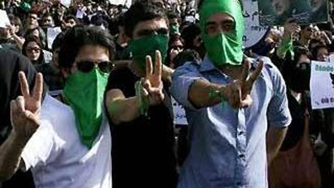 Supporters of defeated Iranian presidential candidate Mir Hossein Mousavi gesture during a protest in Tehran on June 18. (Courtesy of Reuters)