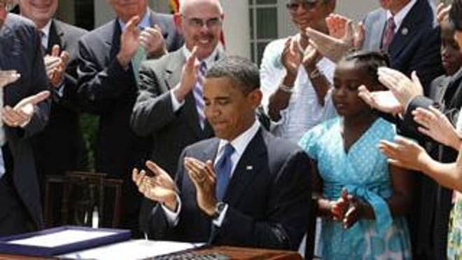 President Obama joins in the applause after signing an anti-smoking bill in the Rose Garden Monday. (Reuters Photo)