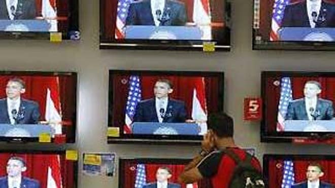 An Israeli watches televisions broadcasting President Obama's speech in Cairo, at an electronics shop in Tel Aviv. (Reuters)