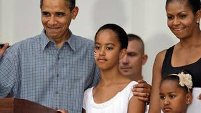 July 4: President Barack Obama, waves with Michelle Obama, right, Malia Obama, who is 11 today, and Sasha Obama, 7.