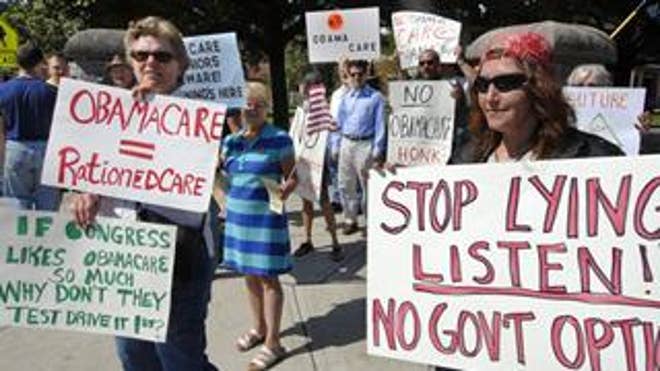 Protesters hold signs during a rally