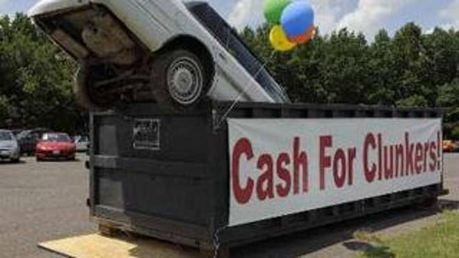 An old car dropped in an industrial trash bin serves as an ad for the cash for clunkers program at Battlefield Ford in Culpeper, Va., Aug. 1. (Reuters Photo)