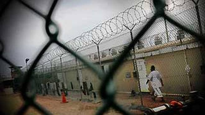 A detainee walks in Camp 4 at the Guantanamo Bay detention facility. (AP Graphic)