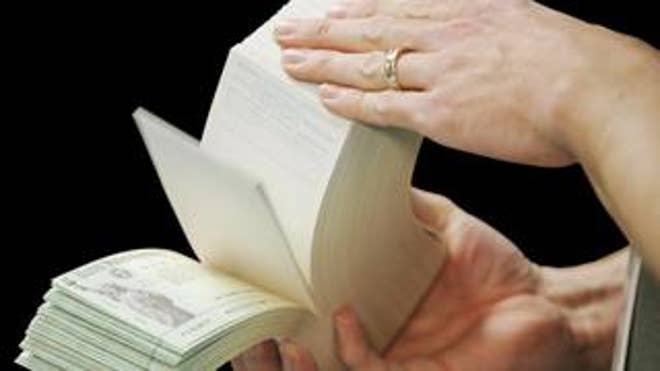 Stack of stimulus checks held in hands