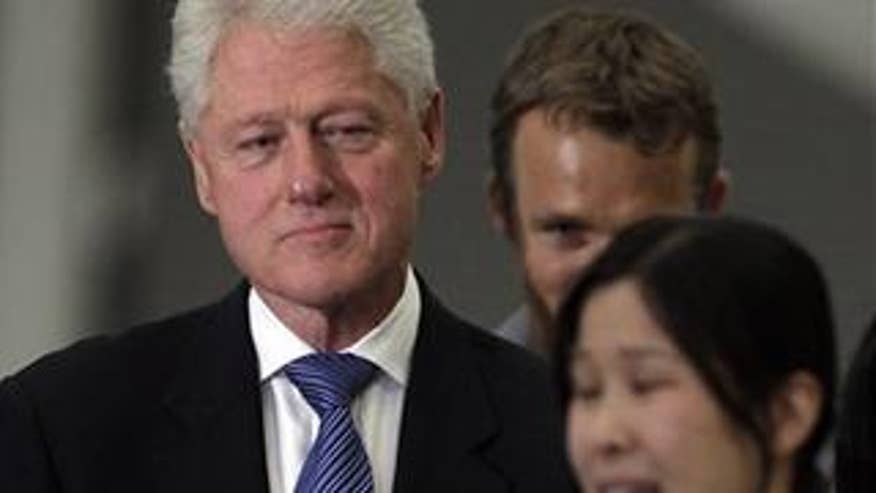 Former President Bill Clinton listens to Laura Ling
