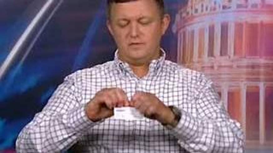 Retired U.S. Army Sgt. Cameron Jones tears up his AARP membership card.