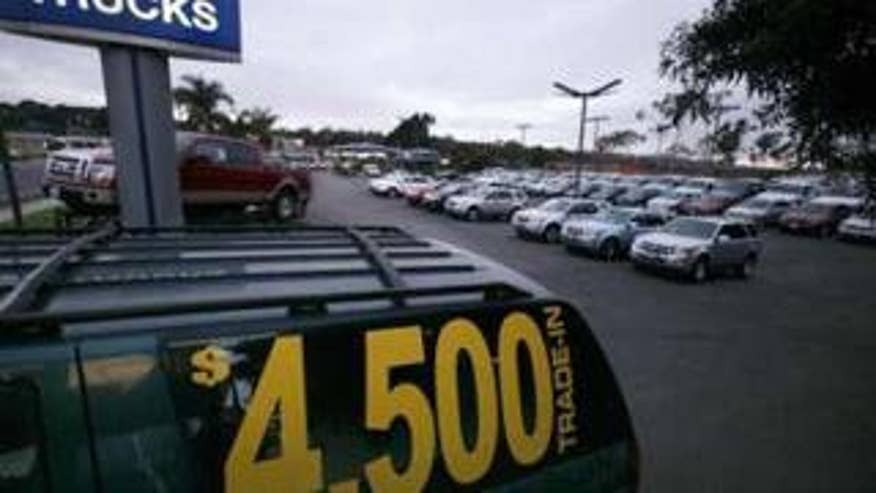 An old vehicle sits on a Ford dealership lot advertising the government's "cash for clunkers" program in Encinitas, Calif., Aug. 2. (Reuters Photo)