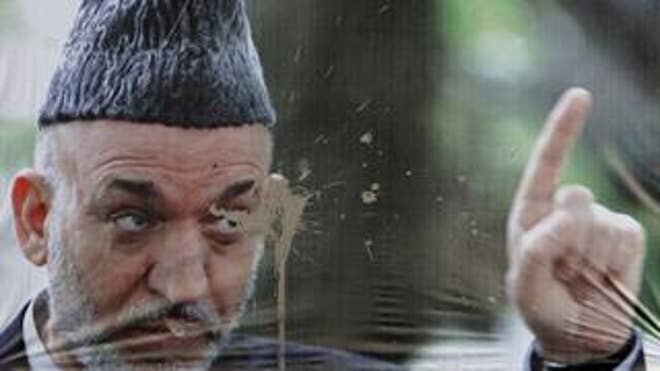A defaced election poster of Afghan President Hamid Karzai is seen in Kabul, Afghanistan, on Oct. 19. (AP Photo)