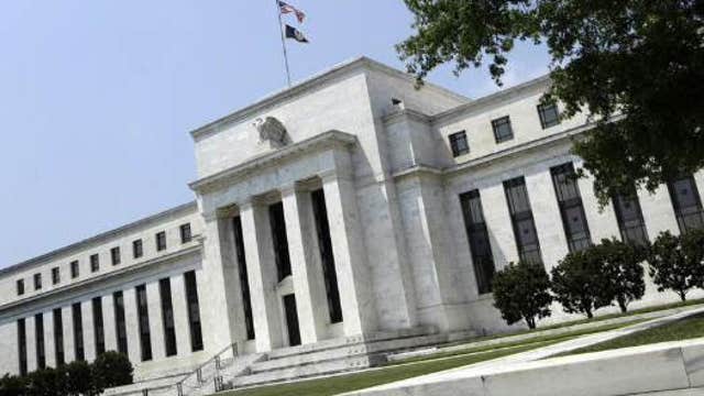 Fed gives positive assessment of economy, cuts bond purchases
