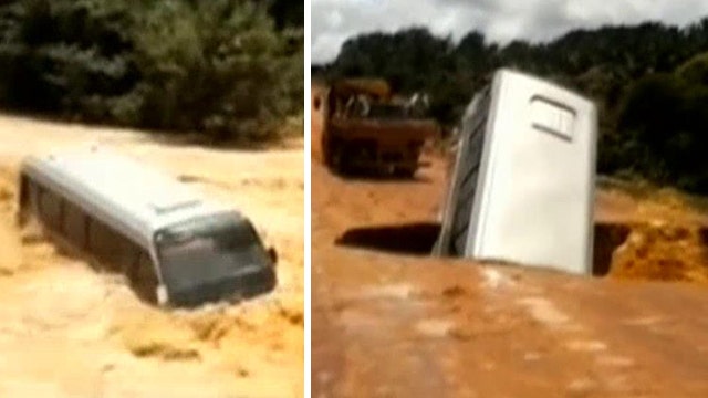 Incredible video: Bus falls in crater, swept away by river