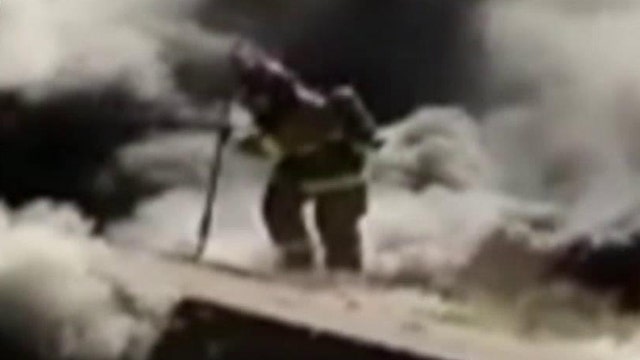 Firefighter falls through roof of burning home