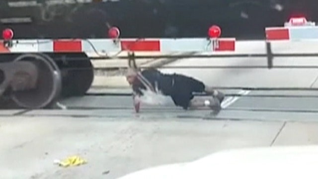 Risky stunt caught on tape as man rolls under train