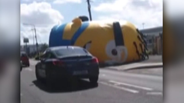 Chaos as giant Minion rolls down street, over cars