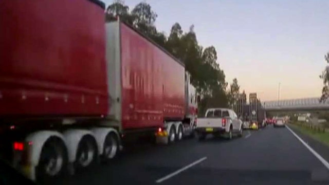 Big rig barreling down highway barely misses stopped traffic