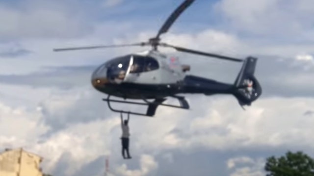 Man hangs from flying chopper for a mile