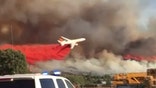 Giant tanker swoops dangerously low to douse wildfire