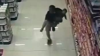 Raw video: Off-duty military policeman in Brazil shoots, kills two robbery suspects in pharmacy while holding his young son.