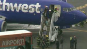 Southwest Airlines flight makes emergency landing in Philadelphia after a passenger was reportedly 'partially sucked out' an airplane window when an engine exploded in midair.