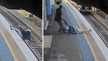 Raw video: Security footage captures man falling onto tracks fellow commuter pulling him from the path of an oncoming train as it grinds to a halt at Sydney station.